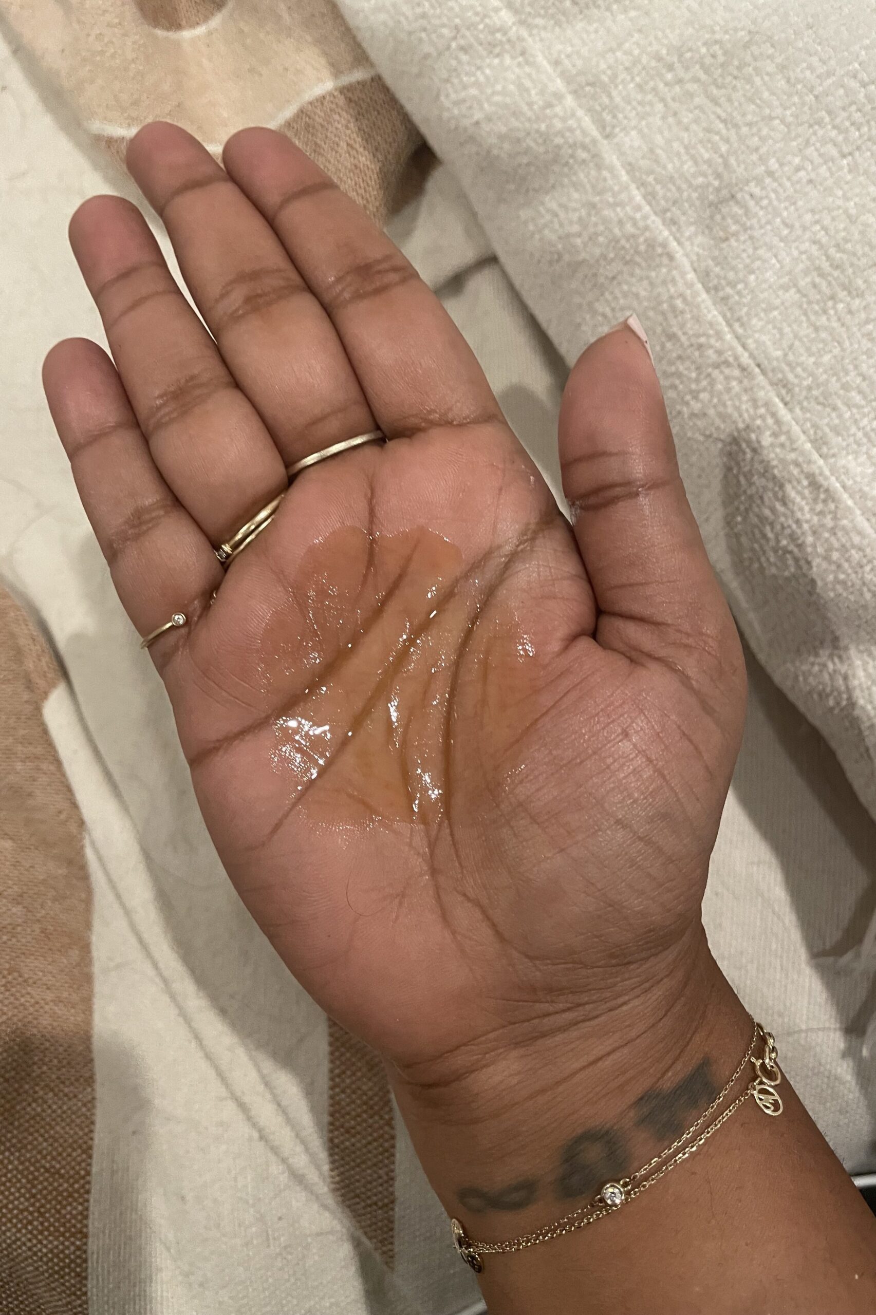 A person's hand with true botanicals liquid on it.