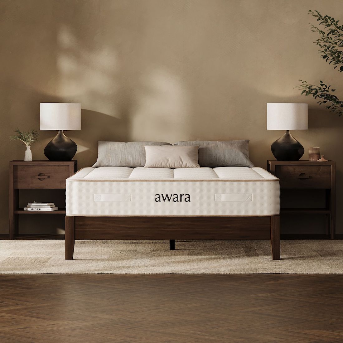 The bedroom showcases a plush bed with an "awara" nontoxic mattress, flanked by two wooden nightstands and lamps, all set against a neutral wall.