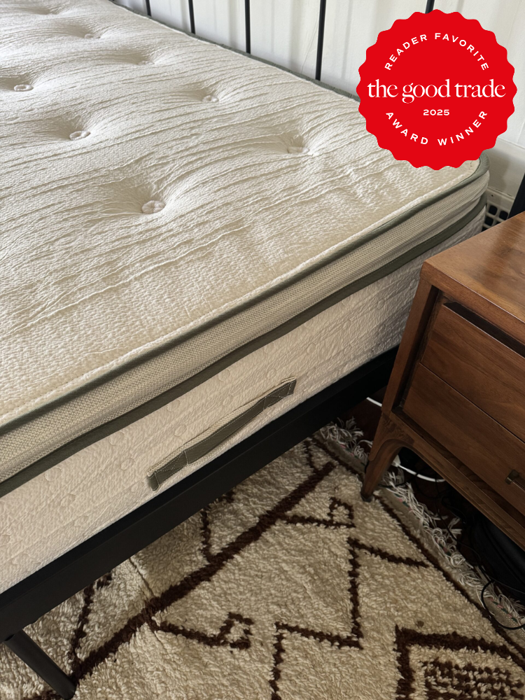 A neatly made bed with a white mattress, a patterned rug underneath, and a wooden nightstand beside it. A red badge on the image reads, "Reader Favorite, AlsWell Blog, 2025 Award Winner.