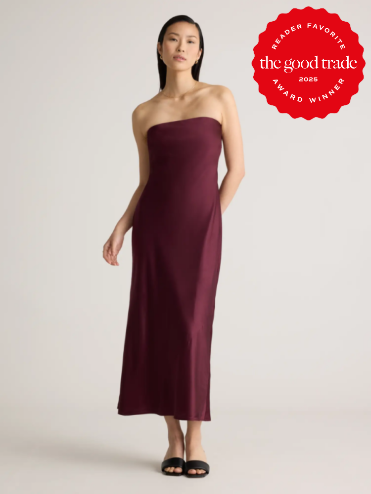 Woman in a strapless burgundy dress and black sandals stands against a plain background. A red badge reading “AlsWell Blog Reader Favorite Award Winner 2025” is on the top right.