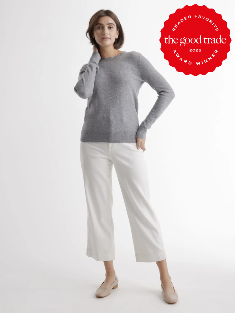 Person wearing a gray sweater and white pants stands against a plain background. A red badge on the top right reads "Reader Favorite AlsWell Blog 2025 Award Winner.