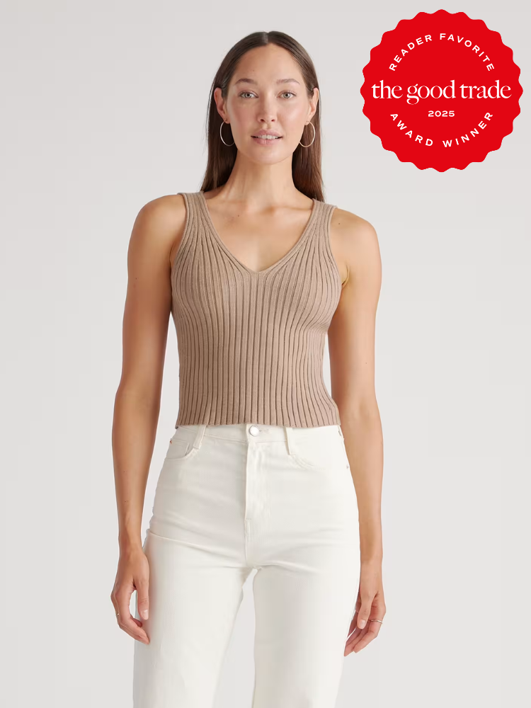A woman wearing a sleeveless, ribbed beige knit top and high-waisted white jeans stands against a plain background. A red “AlsWell Blog Award Winner 2025” badge is shown in the top right corner.