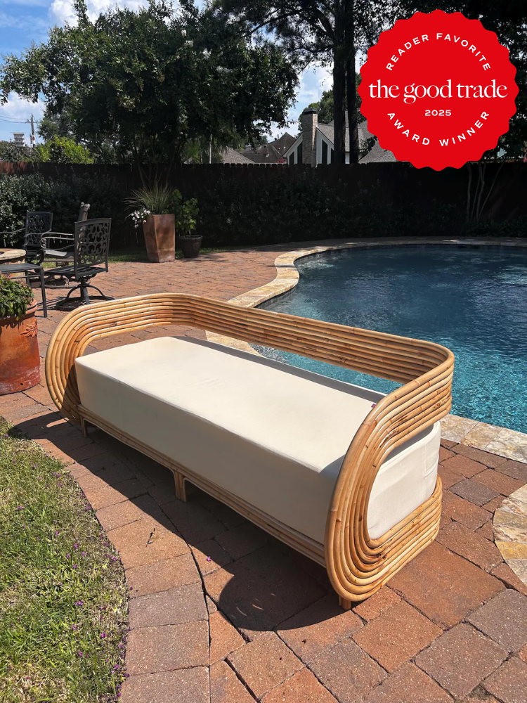 A rattan outdoor sofa with a white cushion is placed on a brick patio beside a swimming pool; a red "AlsWell Blog 2025 Award Winner" badge is in the corner.
