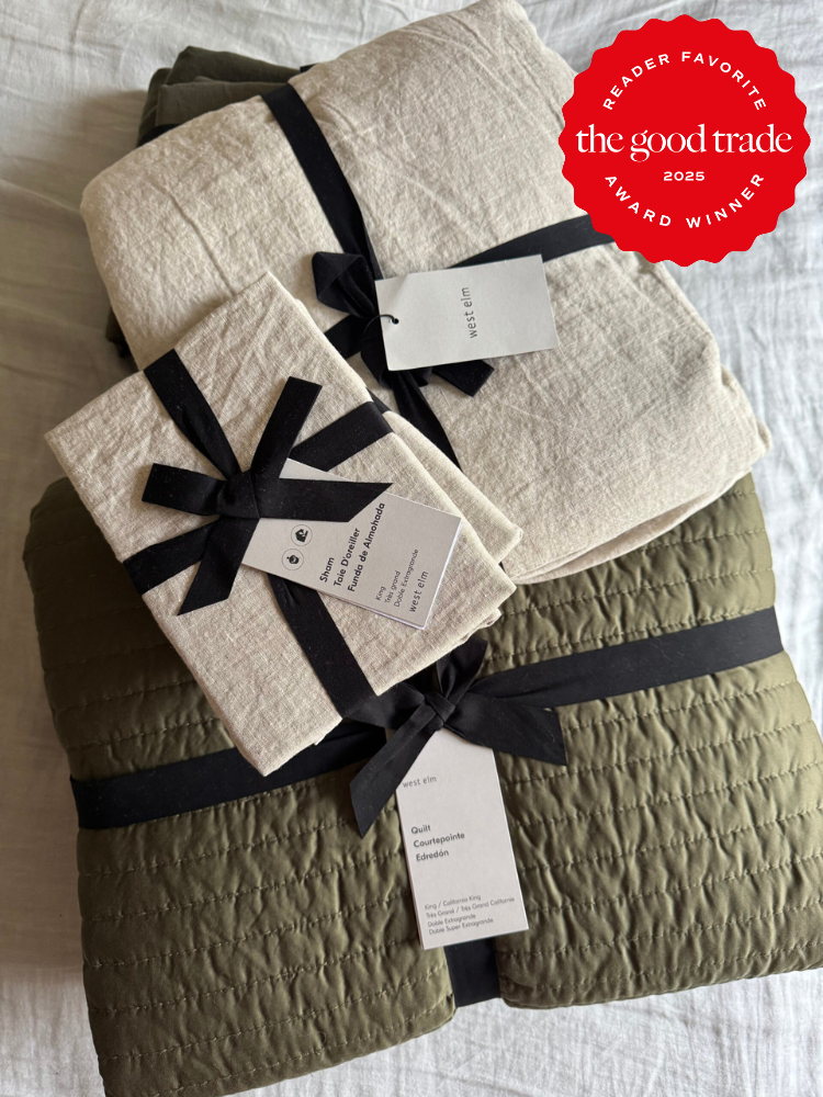 Folded green and beige bedding sets with black ribbons and tags, stacked on a white surface. A red "AlsWell Blog 2025 Award Winner" badge is in the top right corner.